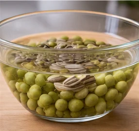 Pois et graines de tournesol trempant dans un bol d’eau